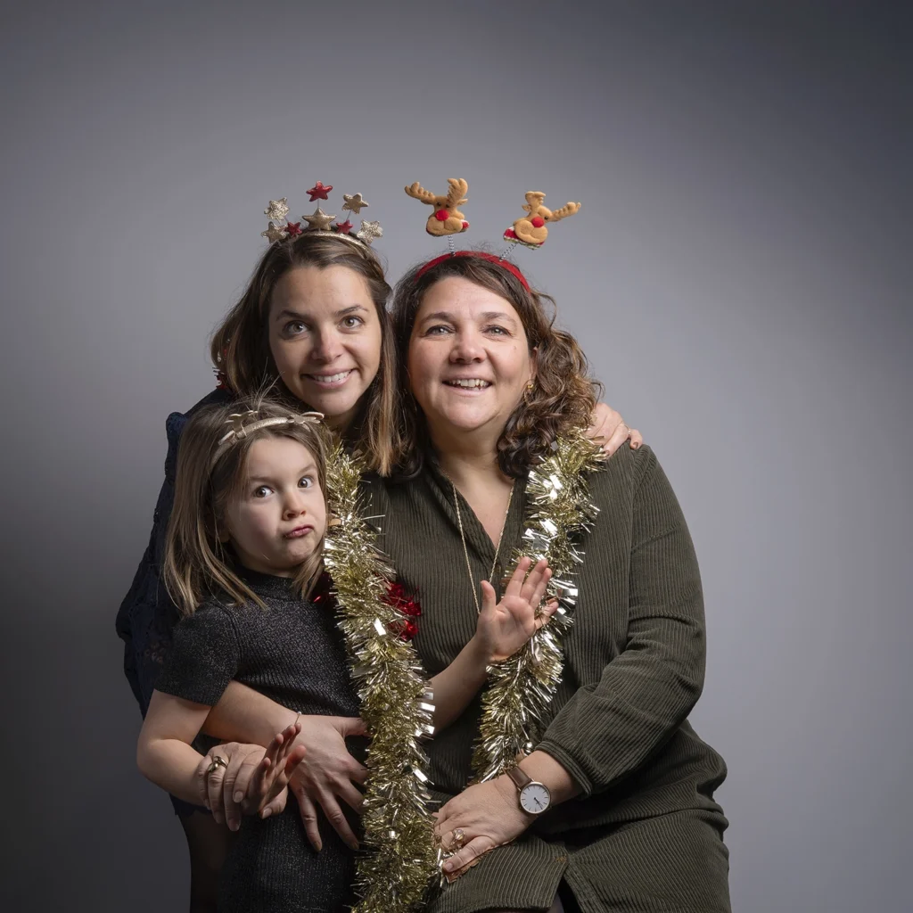 Une maman, une tante et une petite fille réunies pour un portrait de famille à Noël.