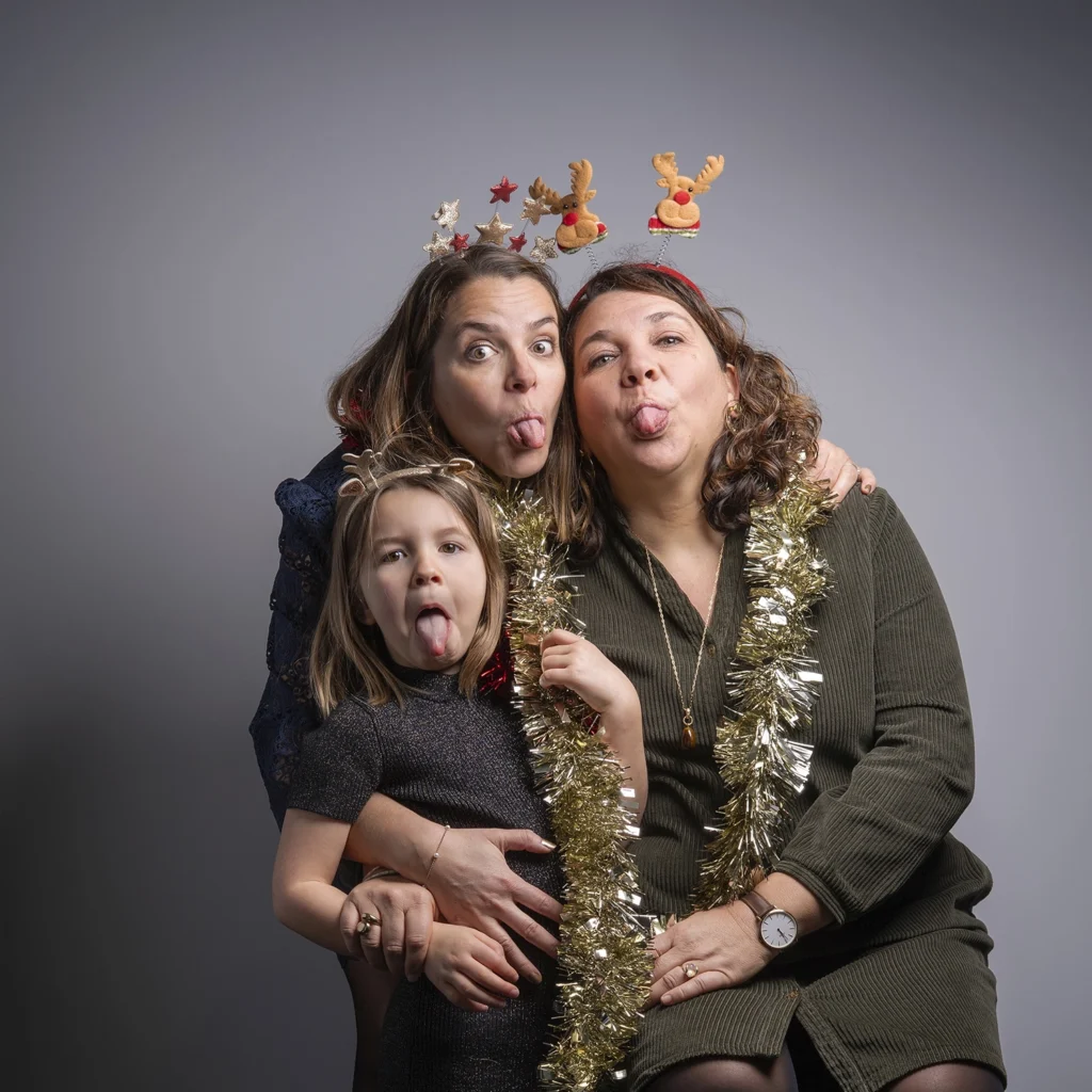 Portrait de deux femmes et d'une petite fille lors d'une séance photo de Noël.