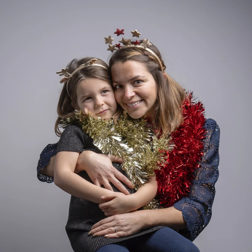 Une maman et sa fille réunies pour un portrait dans un décor de Noël.