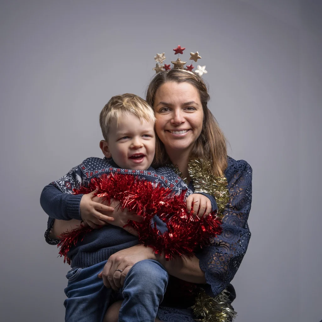 Portrait d'une maman avec son fils dans un décor de Noël.